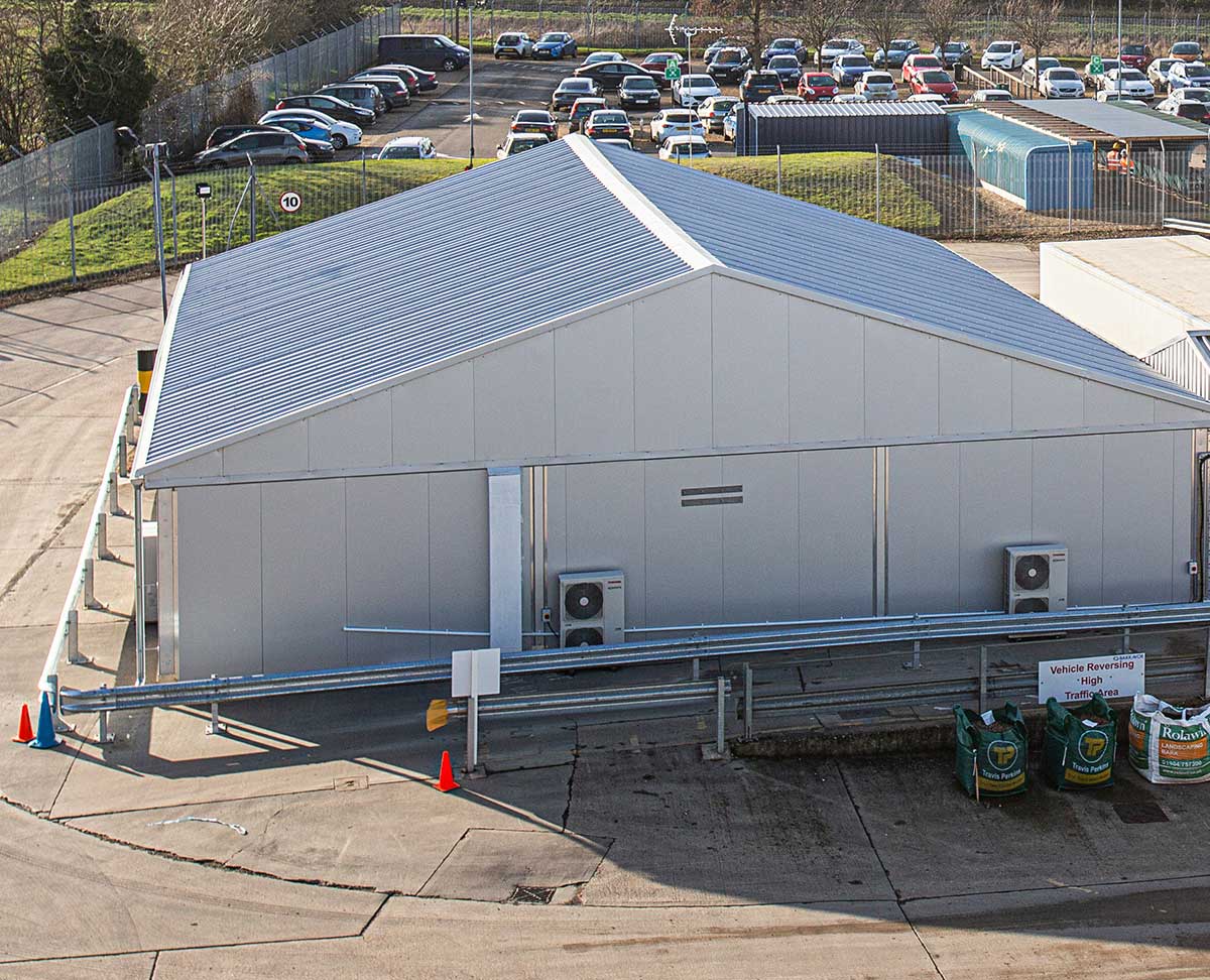 Industrial insulated temporary building with a sandwich panel roof