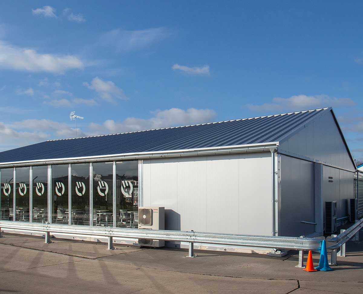Insulated industrial temporary building with a sandwich panel roof