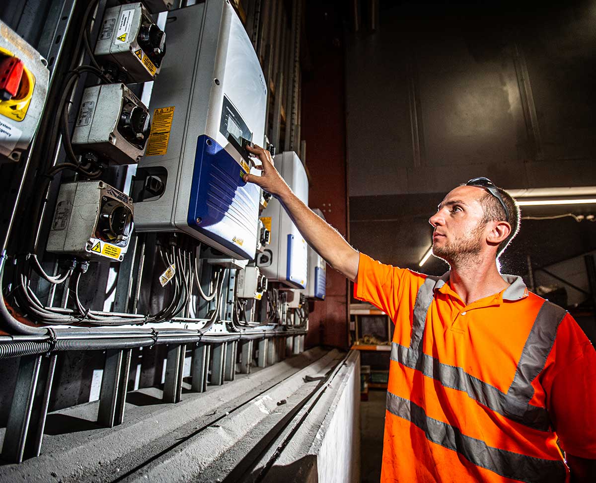 Man in safety vest operating solar power system